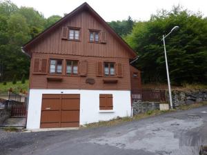 a house with two garage doors at Chalet au Mont-Dore, 300m du centre, 6 pièces, garage, terrain pentu, idéal 8 pers, animaux non acceptés. - FR-1-608-4 in Le Mont-Dore