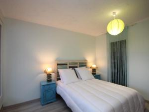 ein Schlafzimmer mit einem großen weißen Bett mit zwei Nachttischen in der Unterkunft Appartement T4 dernier étage au centre avec wifi et parking - FR-1-608-9 in Le Mont-Dore