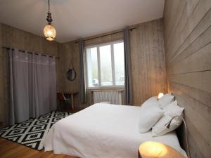 a bedroom with a white bed and a window at Appartement Mont-Dore, 3 pièces, 8 personnes - FR-1-608-1 in Le Mont-Dore