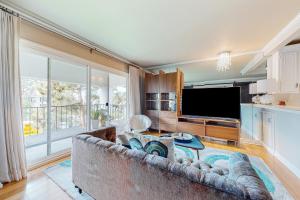 a living room with a couch and a flat screen tv at Rock, Roll, & Relax in Newport Beach