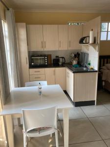 a kitchen with a white table and white chairs at Margaret's Place in Johannesburg