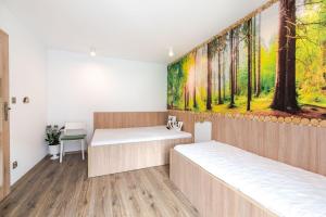 two beds in a room with a painting on the wall at Domki nad morzem in Gąski