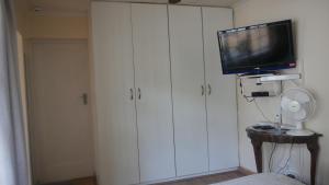 sala de estar con TV y armario blanco en Margaret's Place, en Johannesburgo