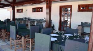 un restaurante con mesas y sillas y copas de vino en Hotel e Pousada Canoa Quebrada, en Canoa Quebrada