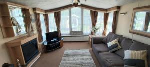 a living room with a couch and a tv at A fashionable caravan in a peaceful seaside town in Sandown