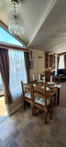 a dining room with a table and chairs and a chandelier at A fashionable caravan in a peaceful seaside town in Sandown