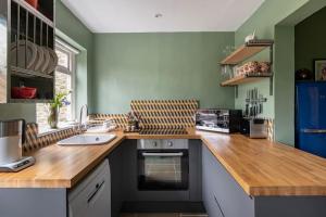 a kitchen with a wooden counter top and a sink at Rumple Cottage in Wingfield