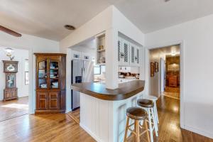 una cucina con pareti bianche, bancone e sgabelli di Ute's Villa a Clearwater Beach