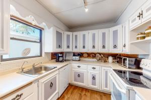 una cucina con armadietti bianchi e una finestra di Ute's Villa a Clearwater Beach