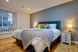 um quarto com uma cama grande e uma janela em Stylish Stamford Centre 2 Bedroom Apartment With Parking - St Pauls Apartments - A em Stamford