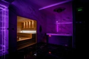 Camera viola con vasca da bagno e porta in legno. di Spa Lux Apatin a Apatin