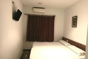 Hotel Las Yucas في Atarfe: غرفة فندقية بسريرين ونافذة