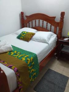 a bedroom with a bed with a wooden head board at Maison créole chaleureuse avec stationnement in Le Gosier