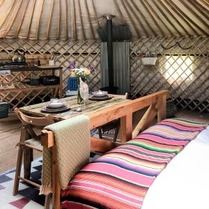 - une table et des chaises en bois dans une yourte dans l'établissement 'Villager' the Yurt at Pentref Luxury Camping, à Penuwch