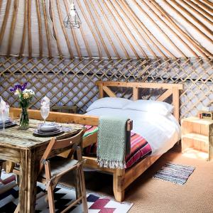 Penuwch的住宿－'Villager' the Yurt at Pentref Luxury Camping，蒙古包内一间卧室,配有一张床