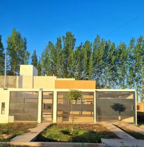 un edificio con dos puertas de garaje y un árbol en Departamento en San Rafael en San Rafael
