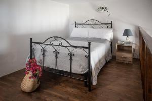 1 dormitorio con cama negra y mesita de noche con lámpara en Casa Serena en Filicudi