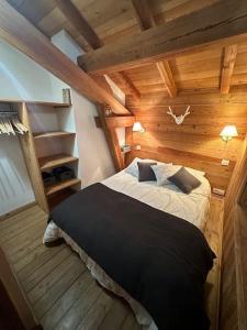 a bedroom with a bed in a wooden room at Chalet l'écureuil La Plagne 8 pers La roche in Praconduit