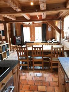 een keuken en eetkamer met een tafel en stoelen bij Chalet l'écureuil La Plagne 8 pers La roche in Praconduit