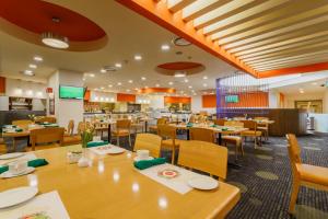 a restaurant with wooden tables and chairs and a cafeteria at Camino Real Aeropuerto in Mexico City