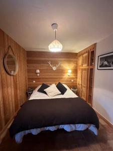 een slaapkamer met een groot bed en een zwarte deken bij Chalet l'écureuil La Plagne 8 pers La roche in Praconduit