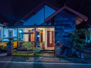 een huis met een voordeur die 's nachts verlicht is bij Homestay dwi prasetyo in Kembanglimus