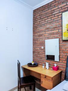 een slaapkamer met een houten bureau en een bakstenen muur bij Homestay dwi prasetyo in Kembanglimus