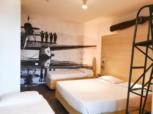 a bedroom with two beds and a mural of a pier at Hotel Perla in Riccione