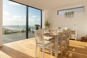una sala da pranzo bianca con tavolo e sedie di Seymour Heights a Woolacombe