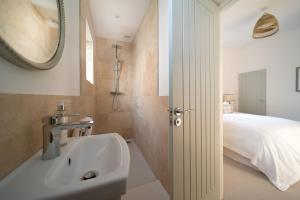 un bagno con un lavandino, un letto e uno specchio di Seymour Heights a Woolacombe