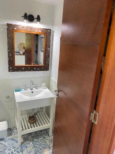 a bathroom with a sink and a mirror at Los Mirlos in La Cumbre