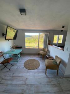 sala de estar con mesa, sillas y TV en Los Mirlos en La Cumbre
