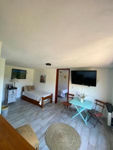 Habitación con cama, mesa y TV. en Los Mirlos en La Cumbre