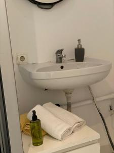 a bathroom with a sink and towels on a shelf at Radisson Charm Studio in Bucharest