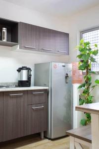 una cocina con nevera de acero inoxidable y armarios de madera en Linda Habitación Privada Polanco 2 camas Mat y baño en Ciudad de México