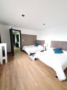 1 dormitorio con 2 camas y suelo de madera en Linda Habitación Privada Polanco 2 camas Mat y baño en Ciudad de México
