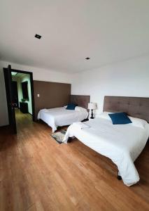 2 camas en una habitación con suelo de madera en Linda Habitación Privada Polanco 2 camas Mat y baño en Ciudad de México