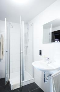 a white bathroom with a sink and a shower at Gentilburg und Gärtnerhaus Aschaffenburg in Aschaffenburg +40 photos
