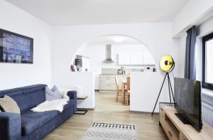 a living room with a blue couch and a kitchen at Gentilburg und Gärtnerhaus Aschaffenburg in Aschaffenburg