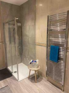 a bathroom with a shower with a stool in it at Hidden Gem w/ parking Short walk to Pleasure Beach in Blackpool