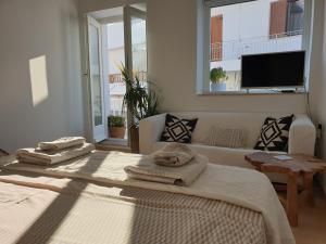 a bedroom with two beds and a couch and a tv at Aretousa Deluxe Downtown Apartment in Skala