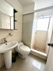 a white bathroom with a toilet and a sink at Apartamento ubicado en Bellas Artes in Caracas