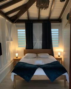 um quarto com uma cama grande e 2 mesas de cabeceira em Le Jardin Zen em Bouillante