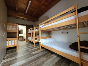 ロレドにあるLa Cala Hostelのウッドフロアのベッドルーム1室(二段ベッド3組付)