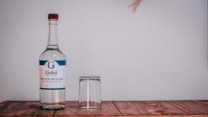 a bottle of wine and a glass on a wooden table at CASA GUIVÁ in Oaxaca City +118 photos