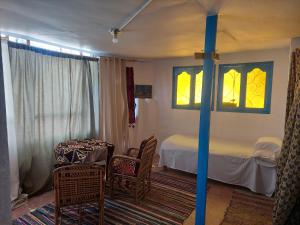 um quarto com uma cama, uma mesa e cadeiras em Nubian studio em Aswan