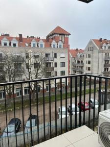 een balkon met uitzicht op een parkeerplaats met auto's bij Apartament Garbary 234 in Poznań