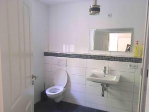 Baño blanco con aseo y lavamanos en Ferienwohnung mit Sauna am Buckowsee, en Buckow