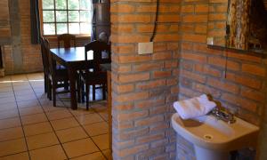 een badkamer met een wastafel en een bakstenen muur bij Hermosa Cabaña de Montaña - Parque La Pirámide 