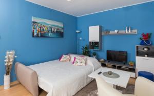 a blue bedroom with a bed and a table at Apartment Fiorella in Dubrovnik
